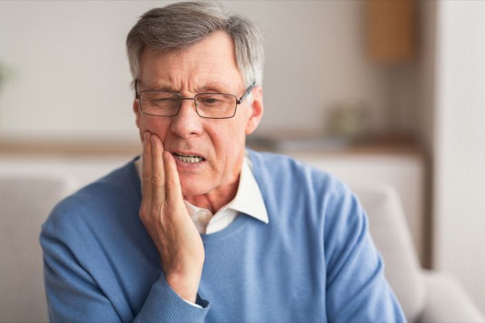 Older man suffering from tooth pain